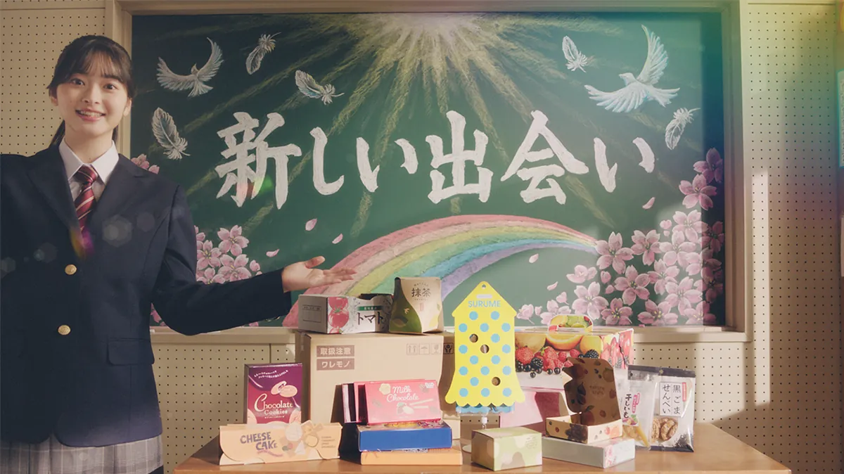 新しい出会いと書かれた黒板の前に立つ堤ひらき