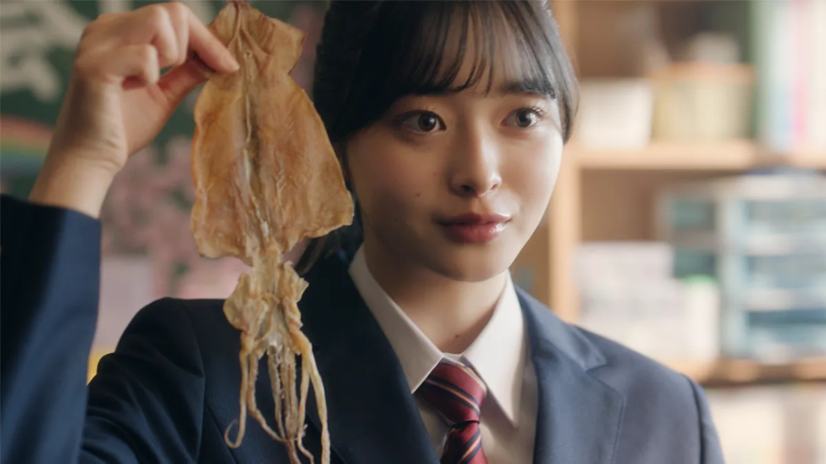 するめを手に持つ堤ひらき