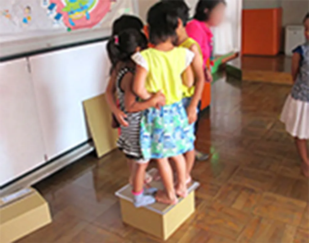 Students testing the strength by standing on corrugated boxes